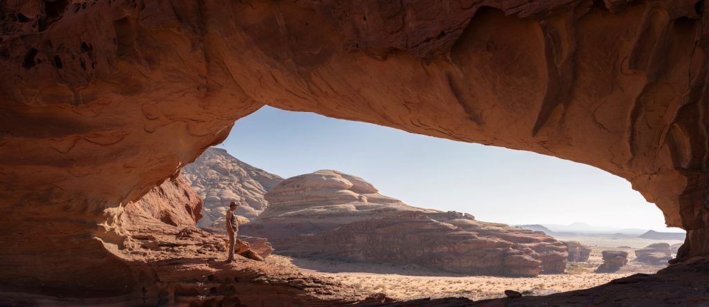 Ranger under a natural rock arch in Al Jour